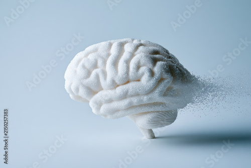 White brain sculpture dissolving into particles, symbolizing memory loss, mental health, aging, and cognitive decline, on light blue background