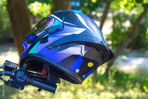 Cuadro en lienzo Close view of a blue full face motorcycle helmet resting on a bike handlebar wit