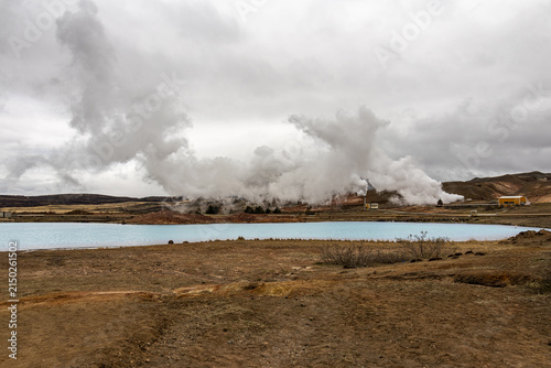 Obraz na plátne Blue silicated geothermal water lake with steam rising from a power plant in the