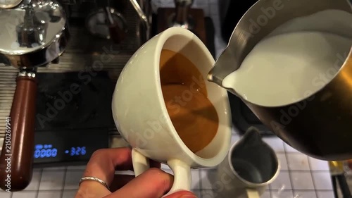 POV Close-Up of Barista Pouring Steamed Milk into Espresso to Create an Intricate Winged Heart Latte Art Design