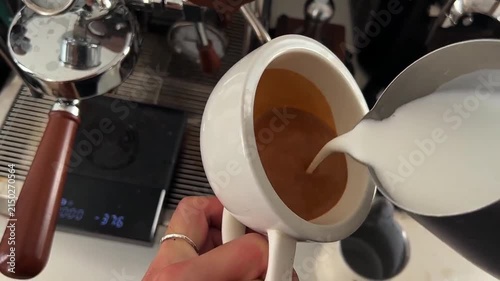 Top View POV Close-Up of Barista Pouring Steamed Milk into Espresso to Create a Rosetta Feather Latte Art Design