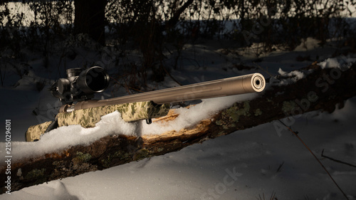 фотографія Bolt action rifle in a snowy treeline in winter