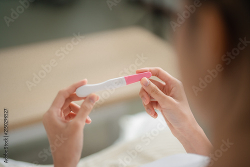 Foto Pregnancy test and reproductive health concept with a woman holding a home test