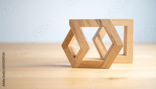 Optical Illusion: A wooden geometric shape, forming an impossible object, sits on a light wooden surface, against a blurred light background, creating a mind-bending visual effect