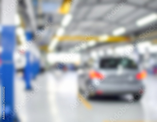Car receiving maintenance in blurred auto repair shop