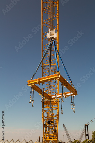 construction heavy machinery equipment,crane holding big metal frame, platform with straps, brackets chains locks, work place at sunset time