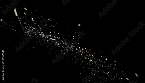 Dynamic Explosion of White Grains and Particles Against a Black Background with Motion Blur