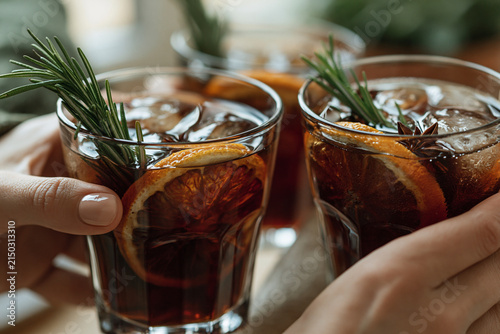 close-up hands clinking dark cocktails 