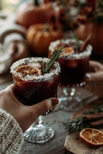 close-up hands clinking dark cocktails 