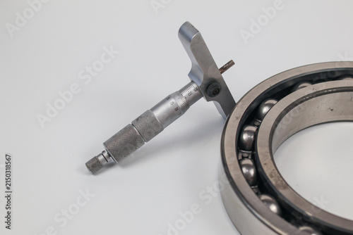 Foto Micrometer depth gauge and steel ball bearing isolated on white background with copy space