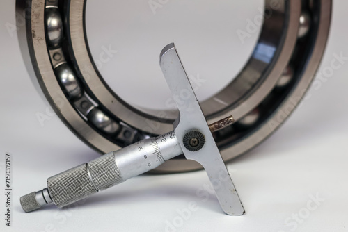 Картината върху платно Measuring steel ball bearing with a micrometer depth gauge isolate on white