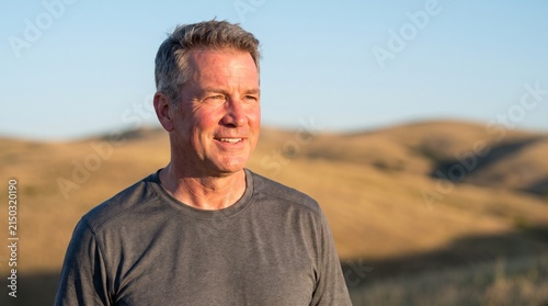 Portrait of an active middle-aged man smiling outdoors in rolling hills