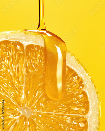 Fresh orange slice with honey on bright yellow background
