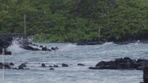 Telephoto shot of Slow motion waves hitting rocks in tortuga bay beach Galapagos