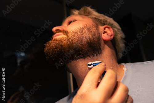 Low Angle View Of Man Shaving Beard Neckline