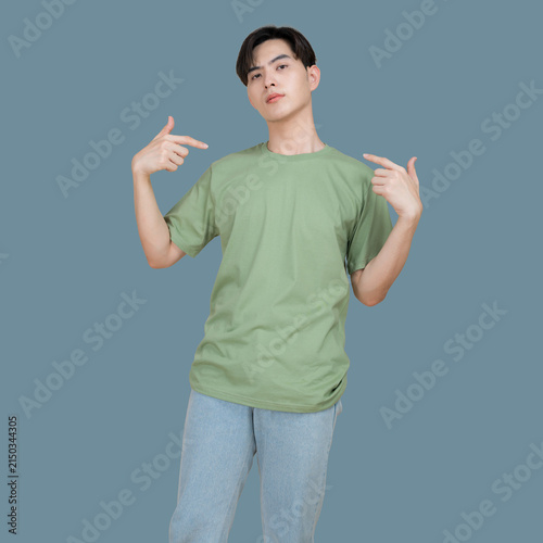 Young man points to himself with a confident expression on a blue background