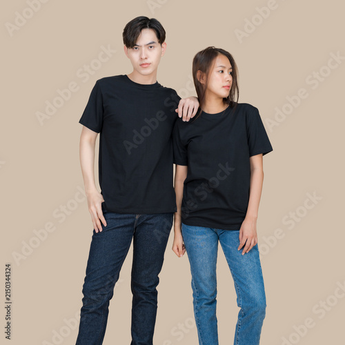 Young Asian couple in matching black t-shirts and denim jeans posing together
