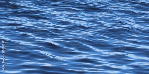 Soft waves on light blue water surface, natural background