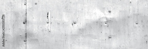 Distressed metal surface showing rivet details on a gray industrial background