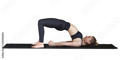 Cuadro en lienzo Young woman performing bridge yoga pose with lifted hips while lying barefoot on