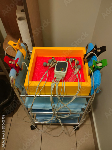 Electrocardiogram ECG machine with multiple electrodes and cables on a medical trolley in a clinic, modern cardiac diagnostic equipment, healthcare technology, hospital examination setup,