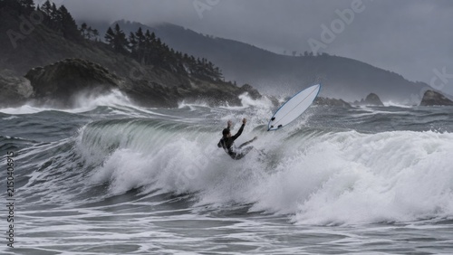 Surfer wiping out shown in a quiet setting with delicate light and thoughtful detail authentic scene