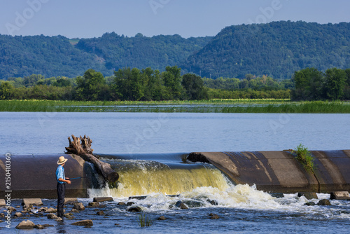A Dam with Waterfall On The Mississippi River with A Fisherman