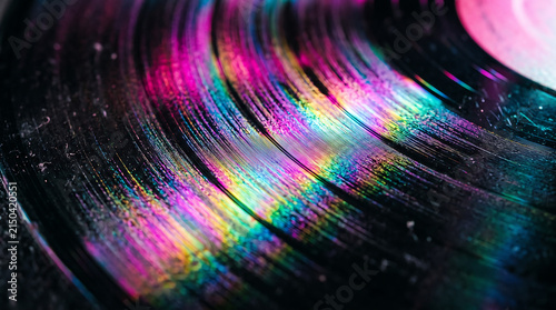 Macro Close Up of Retro Vinyl Record Grooves with Iridescent Rainbow Neon Light Reflection