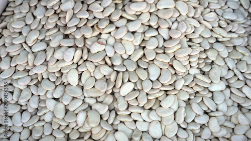 Dense layer of small, pale white dried beans filling the entire frame.