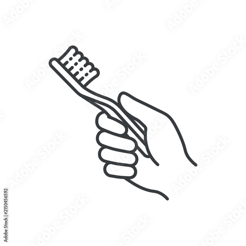 Hand holding a toothbrush for daily dental hygiene.