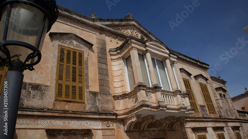 Historic Mediterranean Stone Building with Yellow Shutters in Sunny Town Square,Ciutadella,Menorca,07:06:2026