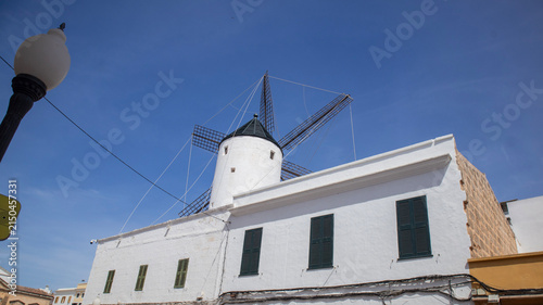 Traditional White Windmill Attached to Building Against Blue Sky