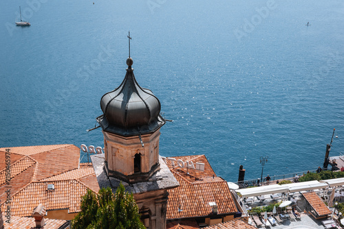 View of a small town near Lake Garda in Italy with a tower and water in the background