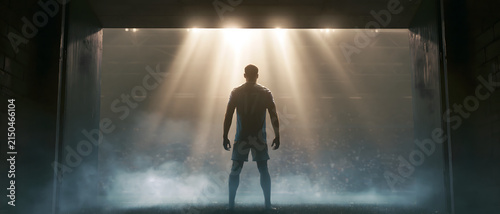 Soccer player silhouette standing in a stadium tunnel with bright lighting athlete competition sportsman footballer arena entrance gateway shadow darkness illumination spotlight radiant
