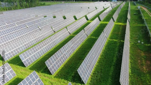 Aerial View Of A Large Solar Panel Farm Generating Clean Renewable Energy In A Forested Landscape