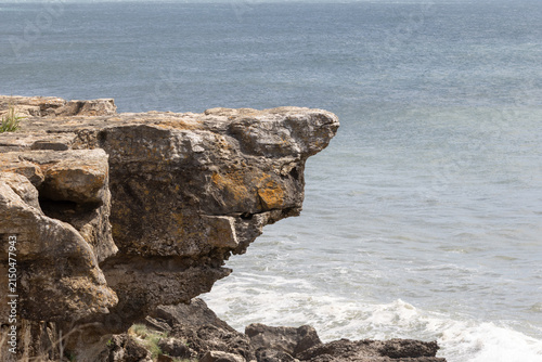 Foto Rugged rock cliff overlooking vast ocean waves in boca do inferno