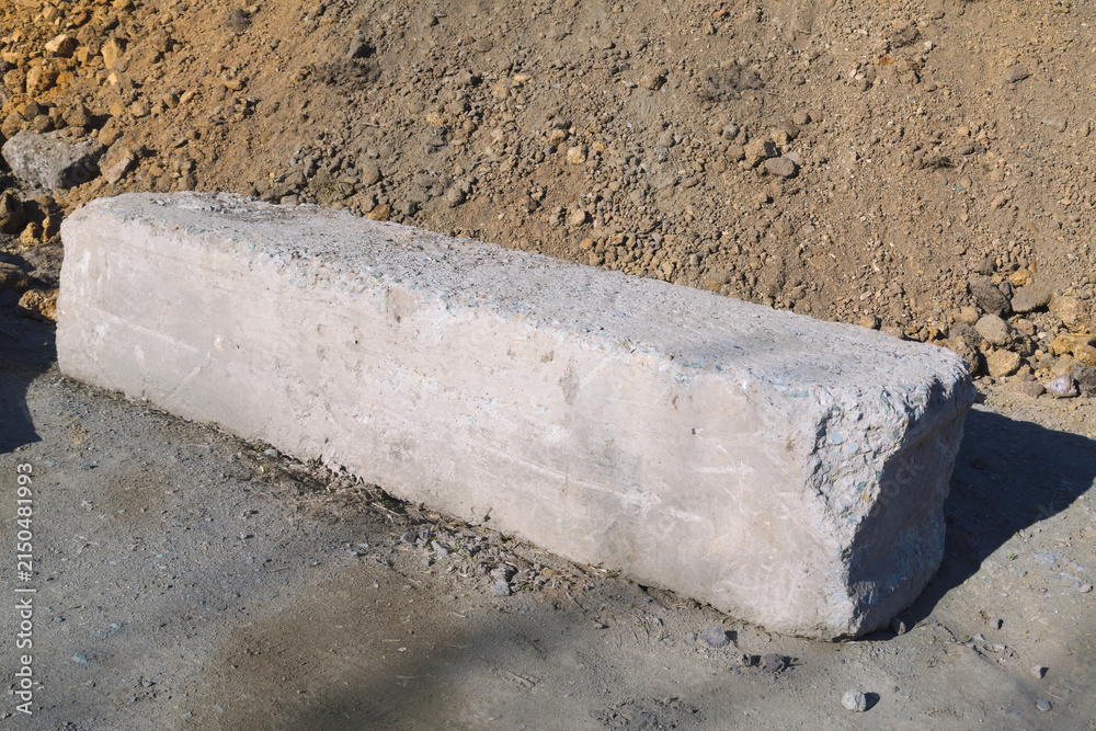 Fototapeta premium Exposed Concrete Block Amid Dirt