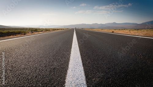 a long empty road with a white line going down it