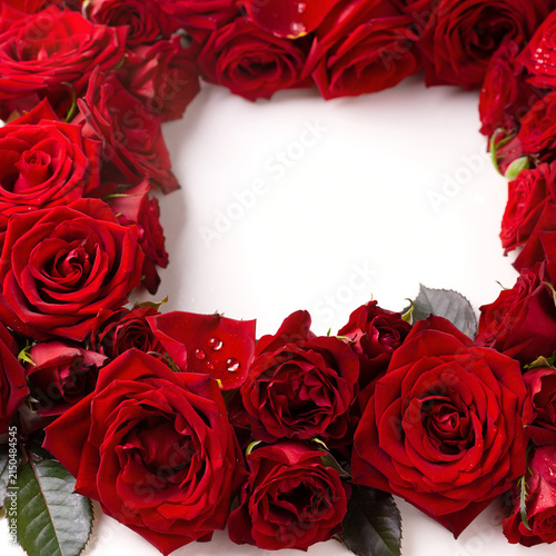 Elegant frame of deep red roses arranged with empty white center