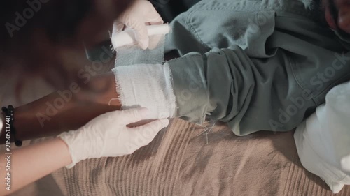 Careful application of bandage. Overview of medical tasks including precise bandage placement. Detailed description of nurse performing careful and textured bandage application procedure