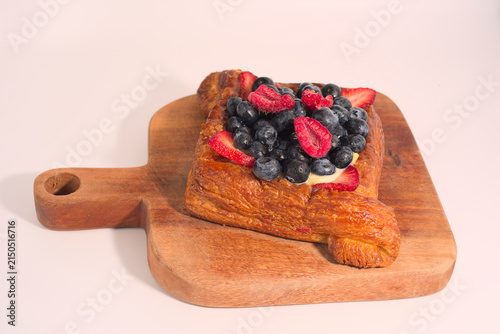 Fotografía Gourmet fruit Danish pastry on wood serving board