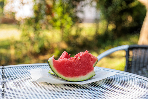 Canvastavla Bitten Watermelon Slice On Plate On Outdoor Patio Table In Sunny Summer Garden P