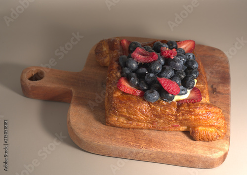 Foto Mixed Berry Danish Pastry on Wooden Board with Neutral Background