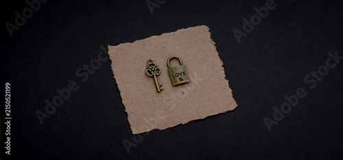 Foto Pair of small antique love padlocks displayed on handmade kraft paper against a dark background, expressing romance, trust, emotional security, and lifelong commitment