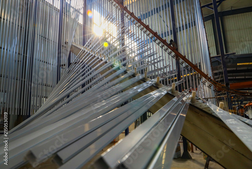 Aluminum extrusion production line inside large industrial workshop, factory manufacturing scene