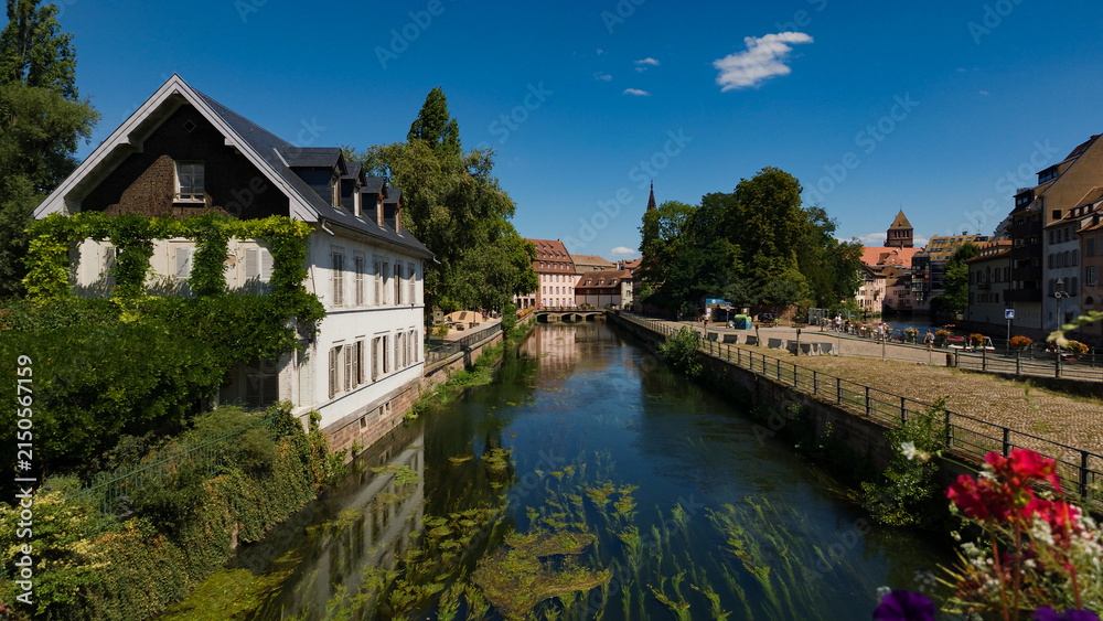 Fototapeta premium Historic buildings lining the tranquil canal in the charming Petite France district of Strasbourg, France