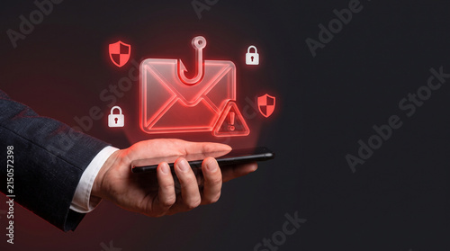 Businessman holding smartphone with holographic phishing email envelope and fish hook icon for cyber attack online scam data breach and internet security awareness concept