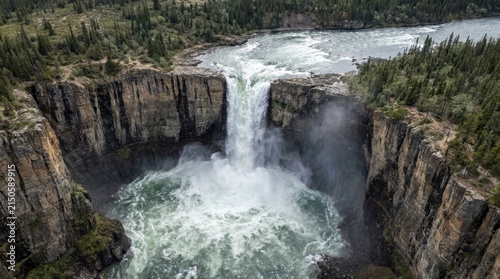 Aerial of drone: powerful waterfall plunging over rugged rocky canyon edge with aerialview, panorama