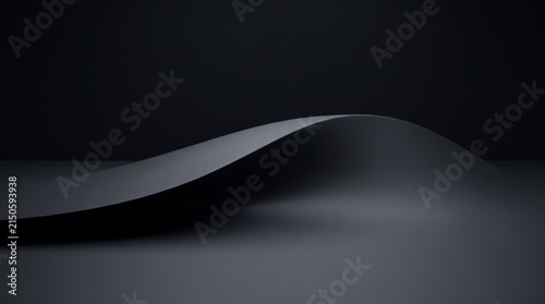 A minimalist and abstract dark grey curved surface against a black backdrop.