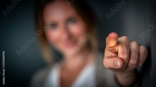 A person pointing a finger directly toward the camera with a blurred background pointing selection